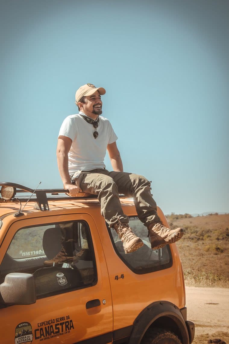Flávio Silva Machado sentado no teto de um 4x4 laranja